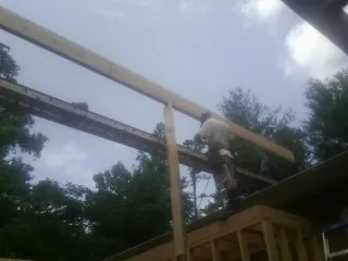 Carpenter setting a ridge beam over a new addition frame — Ice Dam Removal by Roofing Brothers in Tarentum